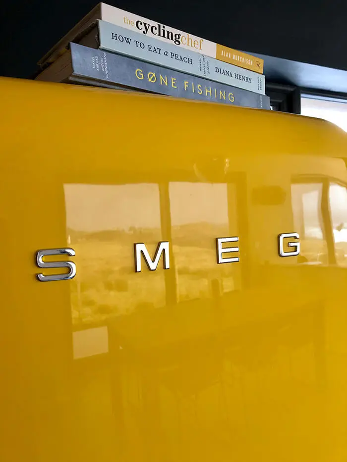 Yellow fridge with three books on top